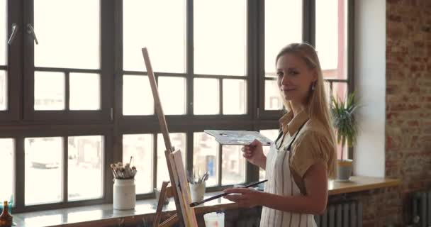 Beautiful young female painter pose for portrait before drawing easel — 图库视频影像