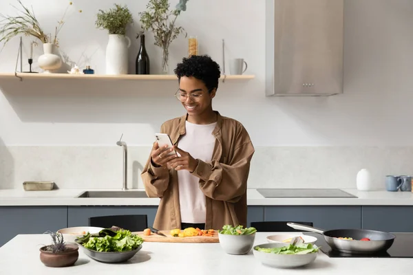 Щаслива дівчина-блогер чорної їжі фотографує інгредієнти салату — стокове фото