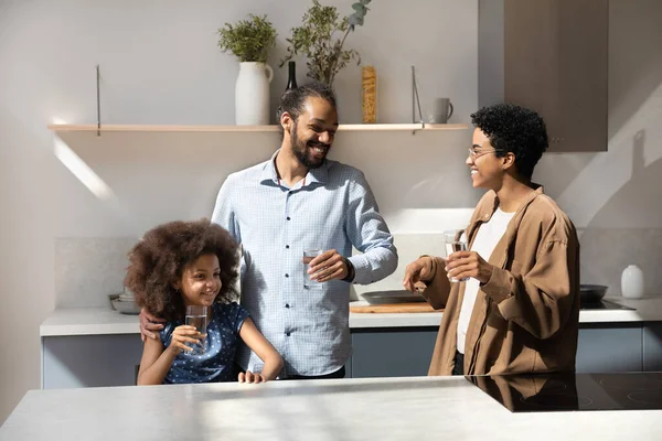 Happy African American family couple and daughter kid drinking water — Stockfoto