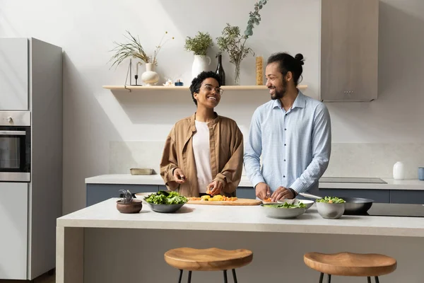 Gelukkig millennial dating Afrikaans paar voorbereiding salade voor het diner — Stockfoto