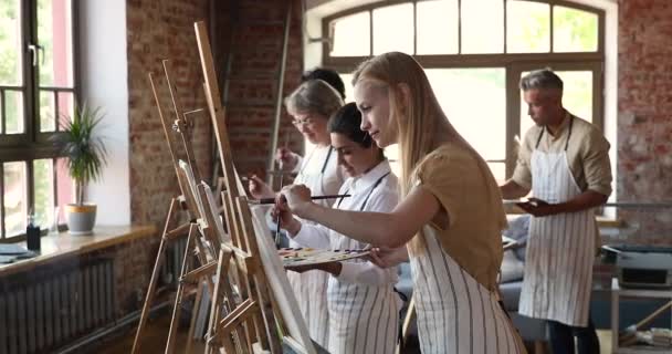 Diversas personas asisten a clases en un estudio de arte dedicado a la pintura — Vídeos de Stock