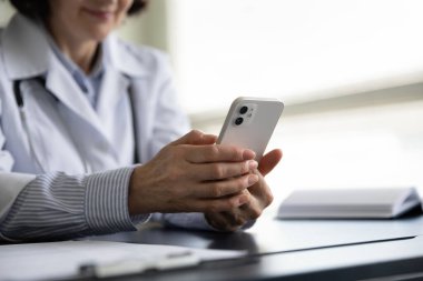 Orta yaşlı kadın doktoru cep telefonuyla kapatın..
