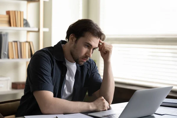 Pensativo infeliz joven empleado masculino que trabaja en la computadora. — Foto de Stock