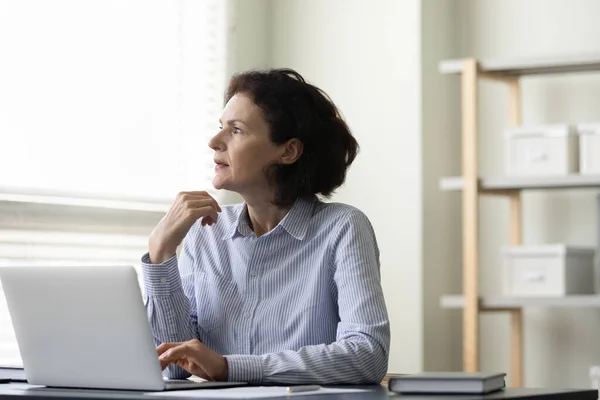 Bedachtzame middelbare leeftijd zakenvrouw werken op de computer. — Stockfoto