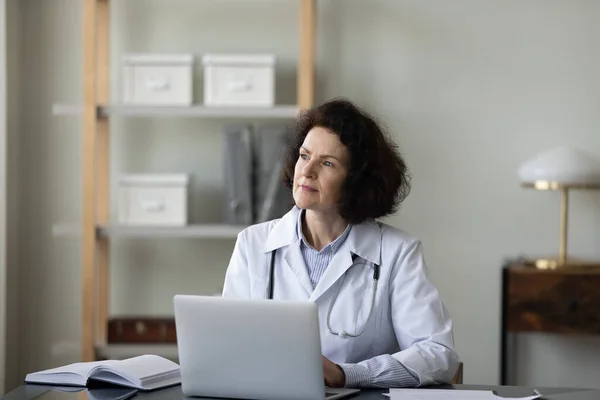 Thoughtful middle aged female doctor considering problem solution. — Stock Photo, Image