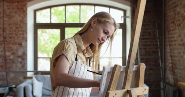 Inspired young woman modern artist paint picture at light studio — Video Stock
