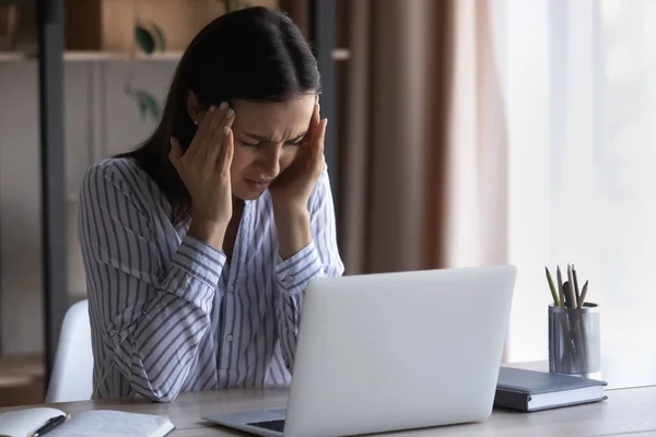 Frustrada mujer joven agotada sintiendo fuerte dolor de cabeza — Foto de Stock