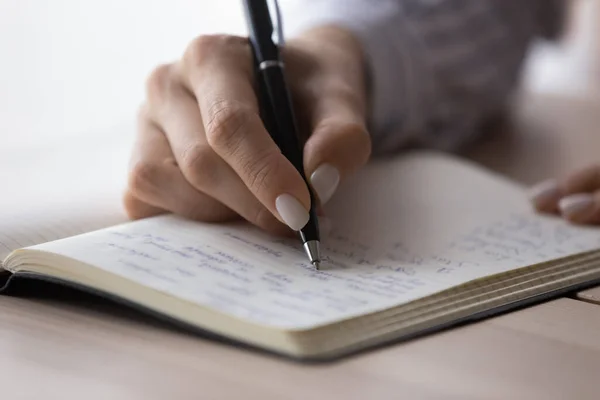 Office employee planning workday, writing list of tasks in notebook — Fotografia de Stock