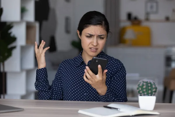 Upset annoyed Indian girl having problems with smartphone — стокове фото