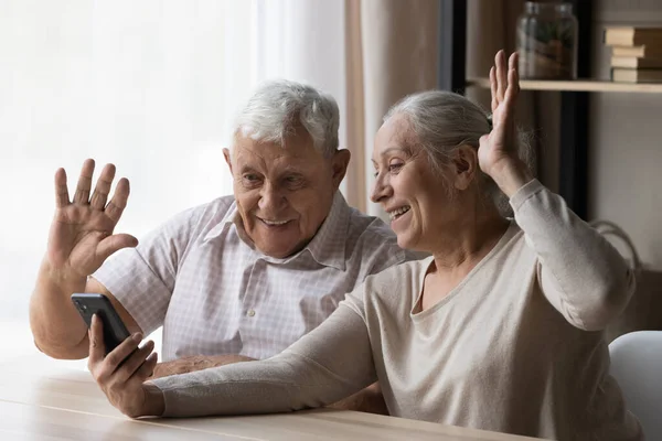 Joyful old mature family couple holding mobile video call. — Stock Fotó