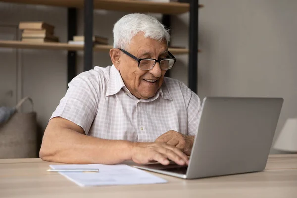 Smiling mature man in eyeglasses working on computer. — Zdjęcie stockowe