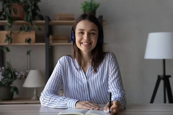 Foto de la cabeza de la joven estudiante milenaria feliz en los auriculares —  Fotos de Stock