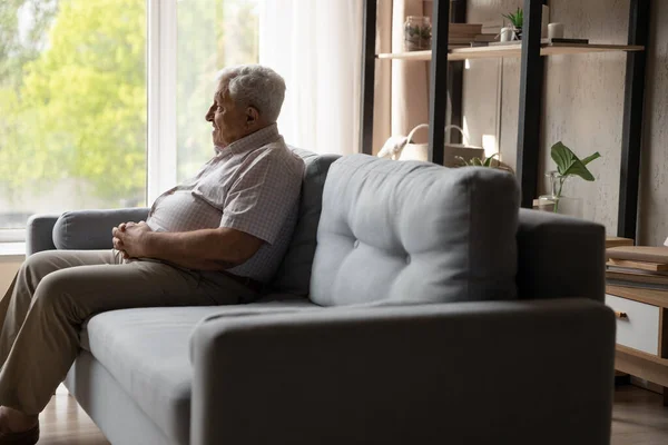 Relaxed happy old 80s man sitting on couch at home. — Stock Photo, Image