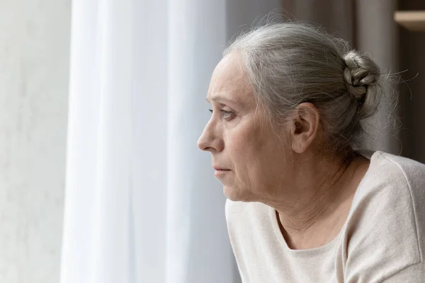 Напряженная несчастная старуха думает о проблемах дома. — стоковое фото
