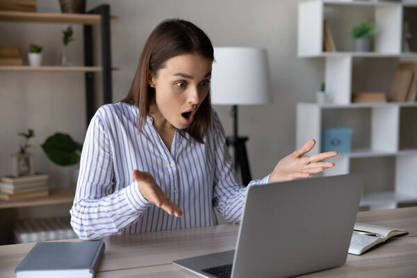 Stressed shocked computer user staring at laptop screen