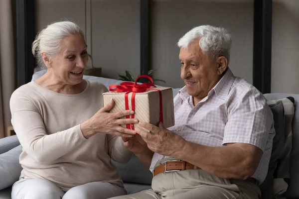 Boldog idős férfi izgatott kapok ajándékot feleségétől — Stock Fotó