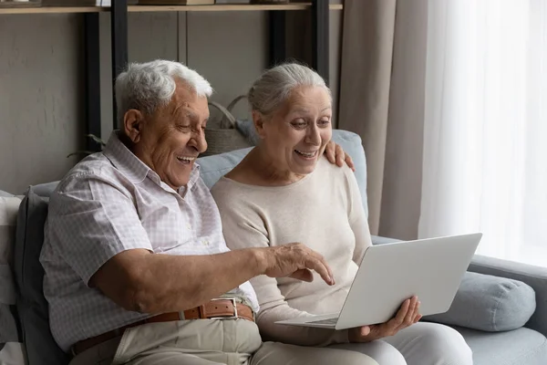 Meglepett boldog öreg család pár számítógép segítségével. — Stock Fotó