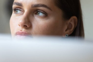 Laptop kullanan düşünceli genç bir iş kadını.