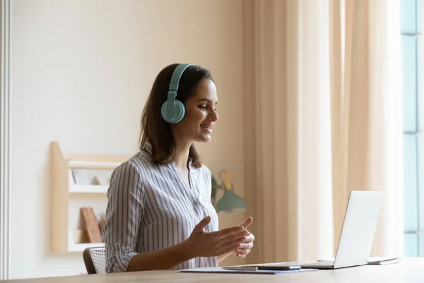 Happy positive online teacher in headphones speaking at laptop webcam — Stock Photo, Image