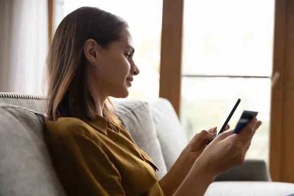 Souriant, réfléchi belle femme client millénaire en utilisant la carte de crédit — Photo