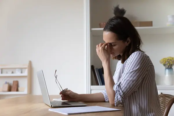 Tired employee woman working at laptop computer too long — Fotografia de Stock