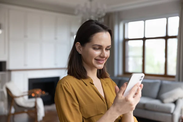 Happy satisfied millennial cellphone user woman browsing internet — стоковое фото