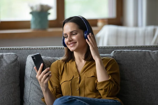 Happy millennial student girl in wireless headphones listening to music — Stock Photo, Image