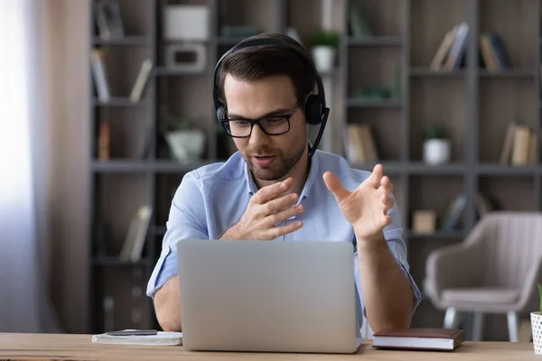 Businessman in glasses and headset talking, making video call — стоковое фото