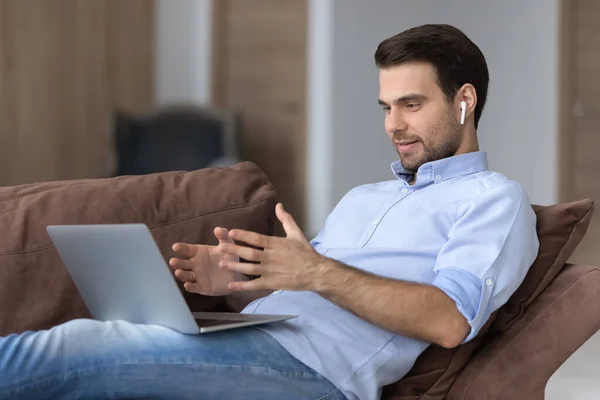 Hombre en los auriculares de chat en línea por videollamada, utilizando el ordenador portátil — Foto de Stock