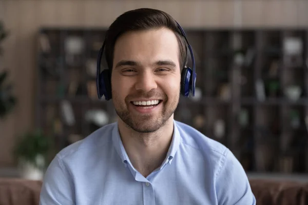Head shot portrait smiling man in wireless headphones chatting online — Stock Photo, Image