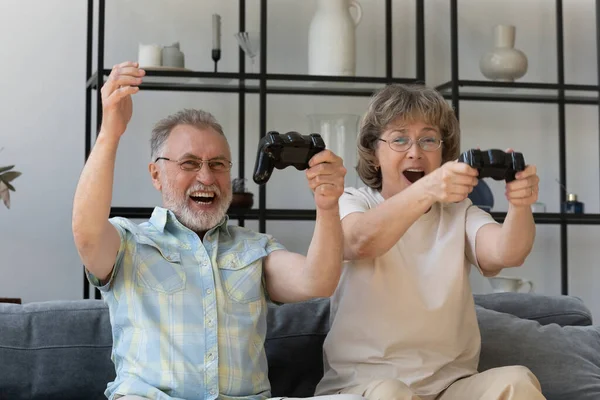 Happy sincere middle aged couple playing video game. — ストック写真