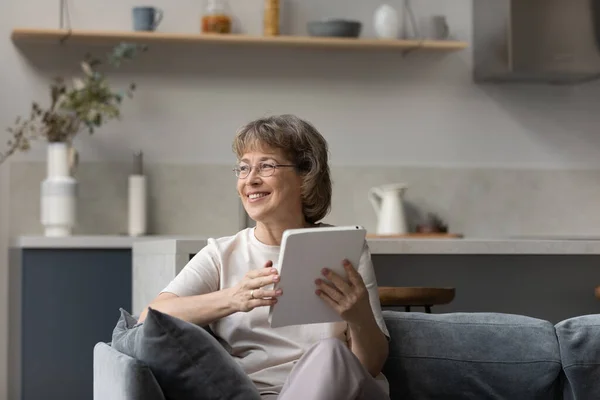 Mujer mayor soñadora feliz usando tableta de computadora digital. —  Fotos de Stock