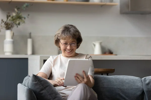 Mujer de mediana edad feliz usando tableta digital. —  Fotos de Stock