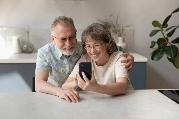 Happy middle aged family couple using cellphone. — Stock Photo, Image