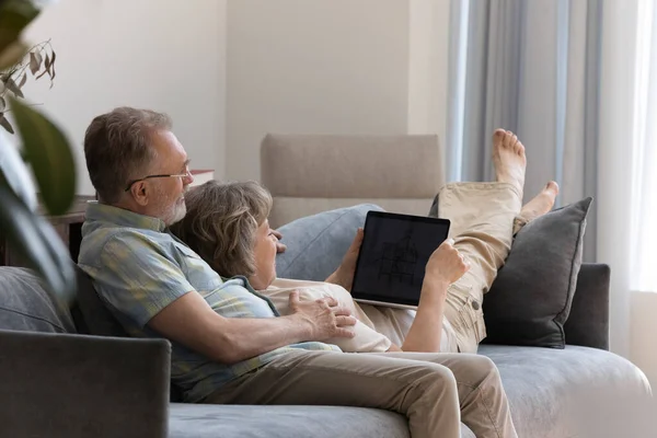 Happy middle aged couple using laptop at home. — Stock Fotó