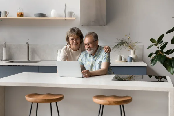 Smiling old middle aged couple using computer apps. — Stock Fotó