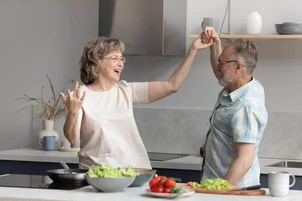 Happy middle aged couple dancing in kitchen. — Zdjęcie stockowe