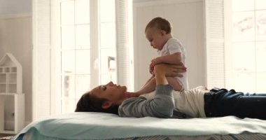 Sevgi dolu anne kucağında tatlı bebeğini kaldırıyor.