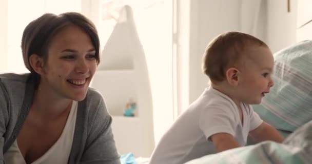 Young mom and baby spend time together in bedroom — Vídeos de Stock