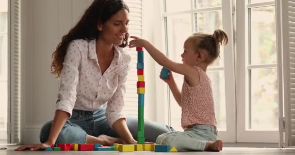 Mãe jogar tijolos de madeira jogos de desenvolvimento com a filha em casa — Vídeo de Stock