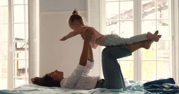 Daughter spread arms like wings flying playing with mother indoors — Stockvideo