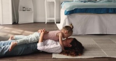 Young affectionate mother touch noses play with little 4s daughter