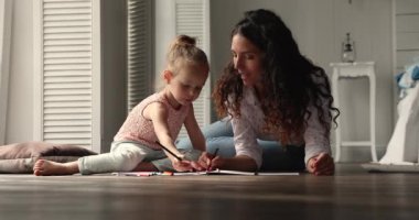 Hispanic woman her daughter drawing in album giving high five
