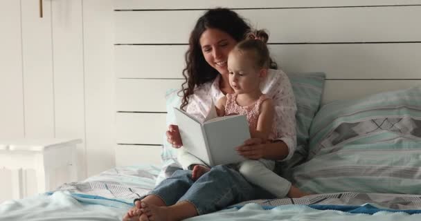 Latina mom read book to her cute little daughter — стокове відео