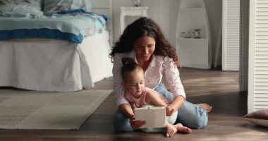 Anne, küçük kızı dijital tablet kullanarak eğleniyor.