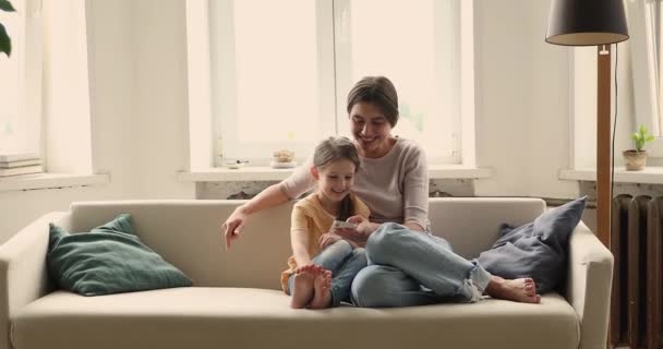 Woman and daughter looking at cellphone screen enjoy mobile application — Αρχείο Βίντεο