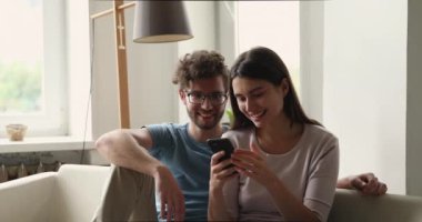 Couple look at cellphone screen scream with joy celebrate success
