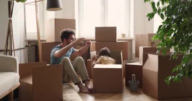 Daughter jumping out cardboard box celebrate relocation day with daddy