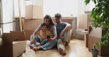 Family resting on relocation day have fun use cellphone