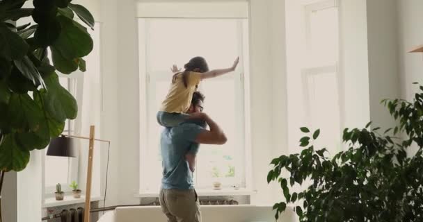 Daughter piggyback ride on daddy back play together at home — Vídeo de Stock